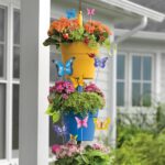 A set of 10 colorful metal butterfly garden stakes with intricate details, standing in a lush green garden bed.