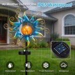 Kacux blue metal sun solar garden stake light with crackle glass globe, emitting a warm glow in an outdoor setting.