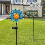 Kacux blue metal sun solar garden stake light with crackle glass globe, emitting a warm glow in an outdoor setting.