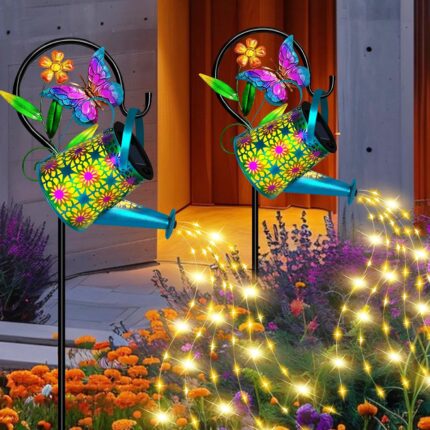 A blue butterfly solar watering can with warm white cascading fairy lights, hanging from a shepherd hook in a garden.