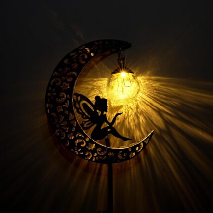 A bronze moon fairy solar garden light with a crackle glass globe, illuminating a pathway at dusk.