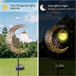 A bronze moon fairy solar garden light with a crackle glass globe, illuminating a pathway at dusk.