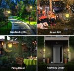 A bronze moon fairy solar garden light with a crackle glass globe, illuminating a pathway at dusk.