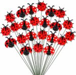 A cluster of 30 red and black 3D ladybug garden stakes, 25cm tall, inserted into green foliage and a potted plant.