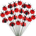 A cluster of 30 red and black 3D ladybug garden stakes, 25cm tall, inserted into green foliage and a potted plant.