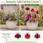 A cluster of 30 red and black 3D ladybug garden stakes, 25cm tall, inserted into green foliage and a potted plant.