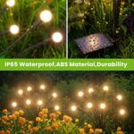Four black solar lights with large, glowing LED bulbs swaying gently in a garden at dusk, resembling fireflies.