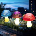 Eight colorful cracked mushroom solar lights staked in a garden bed, glowing with various LED colors.