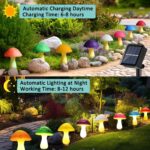 Eight colorful cracked mushroom solar lights staked in a garden bed, glowing with various LED colors.