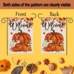 An orange double-sided garden flag featuring a large pumpkin, fallen leaves, and maple leaves, set in an outdoor garden scene
